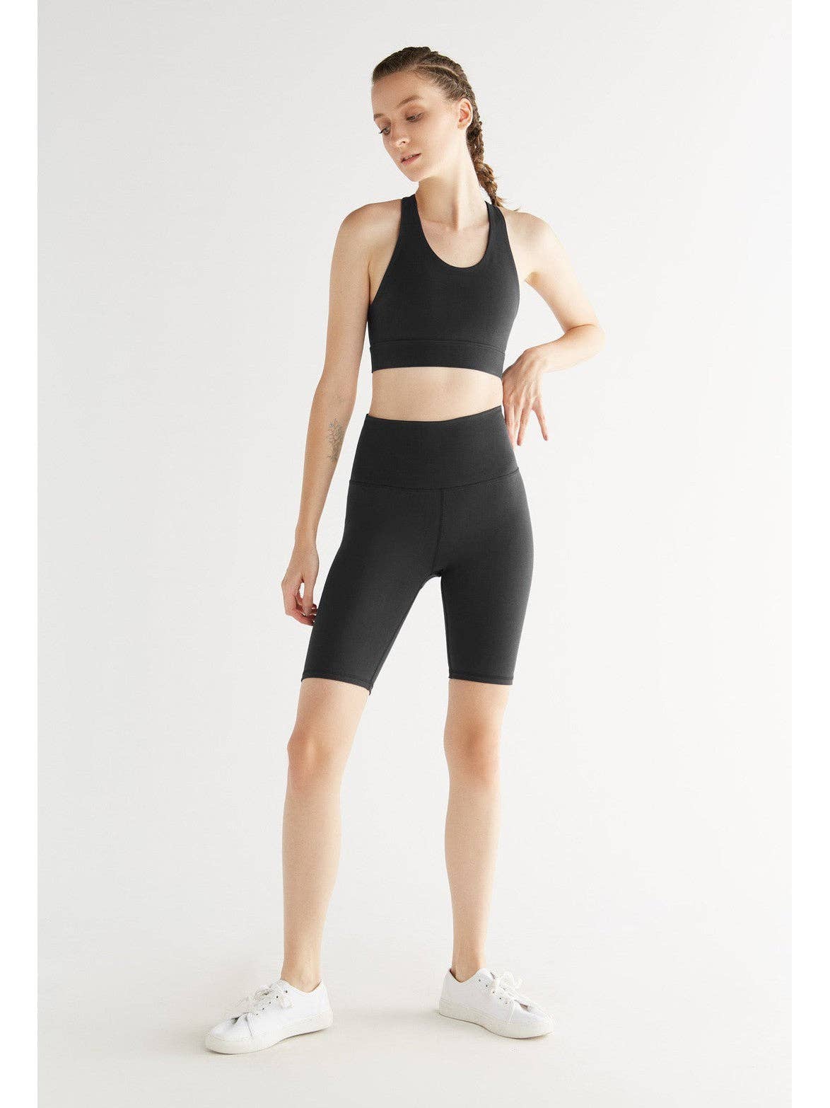 Woman wearing a black athletic outfit on a white background