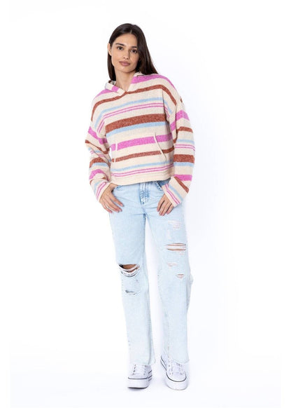 pose of Woman wearing a striped sweater and light blue jeans on a white background