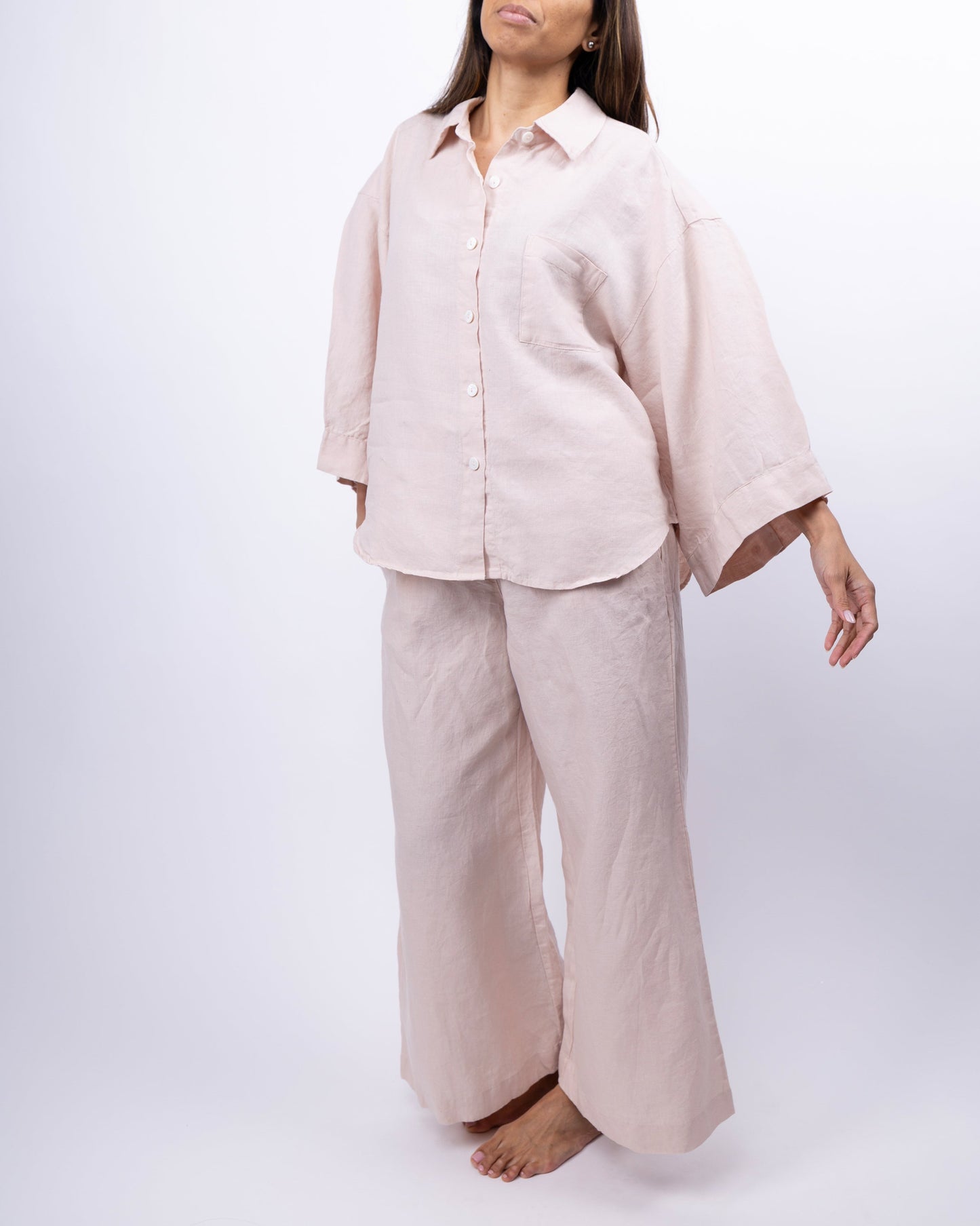 Person wearing a beige linen outfit on a white background